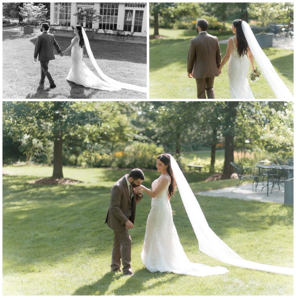 Bride and groom on the lawn with her long veil trailing behind